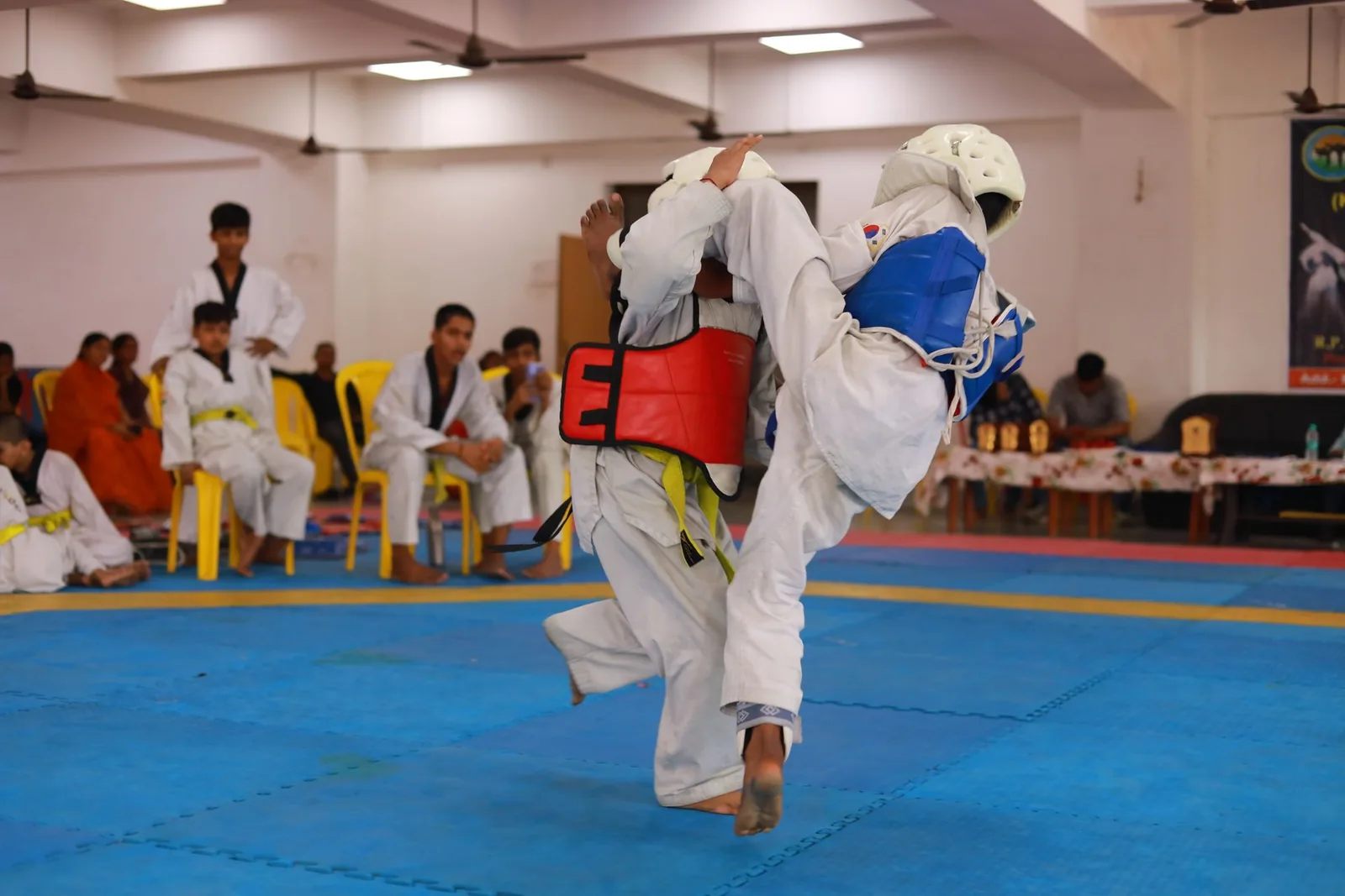 Taekwondo-ottelijat suojavarusteissa kilpailussa