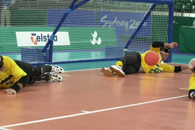 Maalipallon pelaaja torjuu heittoa Sydneyn 2000 paralympialaisissa