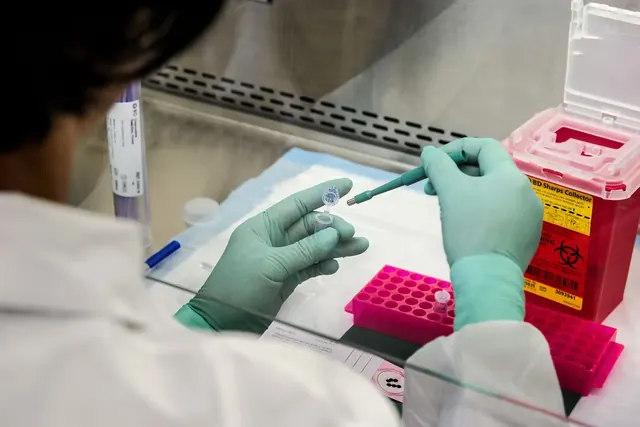 Laboratoriotyöntekijä käsittelee näytteitä
